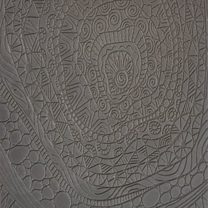 May include: A gray silicone mold with a detailed, intricate design of swirls, circles, and geometric patterns. The mold is textured and has a raised design. The mold is labeled "Cabtopia.com 100492".