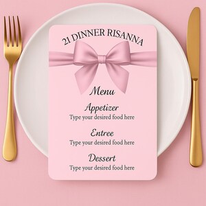 Op de afbeelding: Een roze menukaart met een strik, geplaatst op een wit bord met gouden bestek. De menukaart leest "21 DINNER RISANNA" bovenaan, met secties voor voorgerecht, hoofdgerecht en dessert. De achtergrond is effen roze.