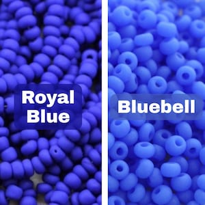 Pu&ograve; includere: Primo piano di due mucchi di perline blu. Uno &egrave; etichettato "Royal Blue" e l'altro "Bluebell". Le perline sono piccole, rotonde e hanno una finitura opaca. Ideali per la creazione di gioielli e l'artigianato.