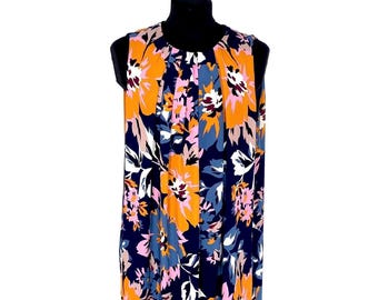 May include: Sleeveless dress with a vibrant floral pattern. The dress features large orange, pink, and white flowers against a navy blue background. The dress is displayed on a black mannequin.
