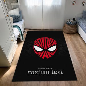 K&ouml;nnte beinhalten: Schwarzer rechteckiger Teppich mit einem rot-wei&szlig;en Spider-Man-Gesichtsdesign. Der Teppich hat das Wort "SPIDERMAN" in einer kreisf&ouml;rmigen Schriftart und den Text "costum text" in Wei&szlig;. Ein Spinnennetz-Design ist sichtbar.