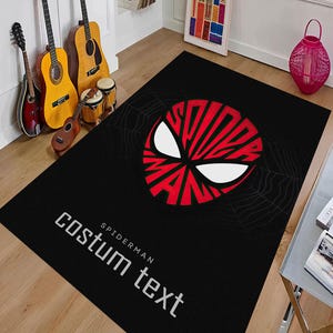 K&ouml;nnte beinhalten: Schwarzer rechteckiger Teppich mit einem rot-wei&szlig;en Spider-Man-Masken-Design. Der Teppich hat die wei&szlig;en W&ouml;rter "costum text" und "Spider-Man". Der Teppich liegt auf einem Holzboden.
