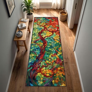 May include: A rectangular runner rug featuring a vibrant mosaic-style pattern of a tree with a dark red trunk and branches, surrounded by a dense canopy of multicolored leaves in shades of green, yellow, orange, and red, with a black border.