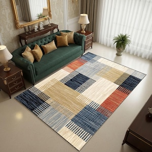 Peut inclure: Un tapis rectangulaire avec un motif géométrique dans les tons beige, bleu, rouge et gris. Le tapis présente un design patchwork avec des lignes entrecroisées, créant un look moderne. Le tapis est posé sur un sol clair dans un salon.