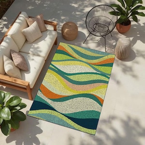 Könnte beinhalten: Ein farbenfroher Outdoor-Teppich mit einem wellenartigen Muster in Grün-, Orange- und Blautönen. Der Teppich liegt auf einer Terrasse mit einem weißen Sofa, Kissen und einem schwarzen Stuhl. Das Design des Teppichs hat eine gepunktete Textur.