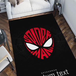 K&ouml;nnte beinhalten: Schwarzer rechteckiger Teppich mit einem rot-wei&szlig;en Spider-Man-Masken-Design. Das Wort "SPIDERMAN" ist in das Design der Maske integriert. Der Text "costum text" ist darunter in Wei&szlig; gedruckt.