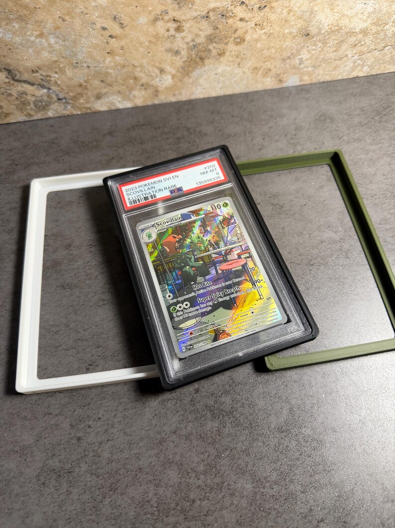 Op de afbeelding: Een beoordeelde Pok&eacute;mon-kaart in een zwarte hoes, met een kleurrijke illustratie van Scovillain. De kaart is gelabeld met "2023 Pok&eacute;mon SV1EN Scovillain Illustration Rare" en is omgeven door witte en groene frames.