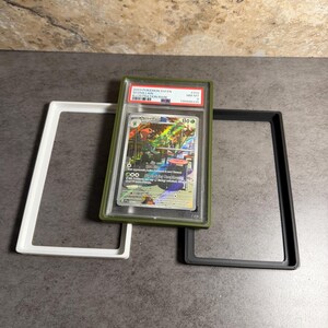Op de afbeelding: Een beoordeelde Pok&eacute;mon-verzamelkaart in een groene houder, met de tekst "2023 Pokemon SWSH Scovillain Illustration Rare". De kaart wordt gepresenteerd met witte en zwarte beschermende frames.