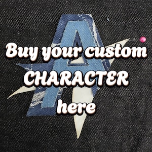 May include: A denim patch in the shape of the letter "A" with a light blue outline and a darker blue center. The patch is sewn onto a dark denim background. Text reads "Buy your custom CHARACTER here."
