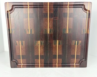 End grain cutting board measuring 15 1/2" x 12 1/2" x 1 1/2" crafted from a combination of padauk, lancewood, zebrawood, and ash hardwoods.
