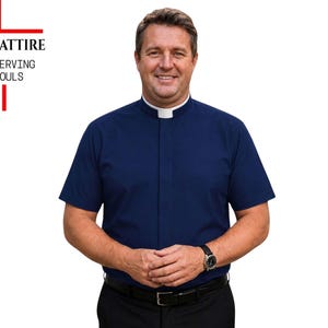 May include: A short-sleeved navy blue clergy shirt with a white tab collar, worn with black trousers and a black belt. The logo in the upper left corner features a red cross design with the text THE CLERGY ATTIRE SERVING SOULS.