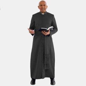 Puede incluir: Una sotana negra con cuello mao y abotonadura frontal. La sotana tiene una faja a juego con un extremo con flecos. El texto "THE CLERGY ATTIRE SERVING SOULS" está visible.