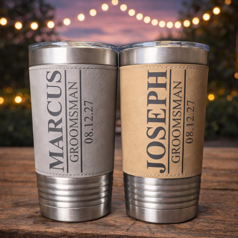 May include: Two stainless steel tumblers with personalized leather sleeves. One is gray and the other is tan. Each has a name, the word "Groomsman", and a date printed in black. The tumblers have a silver lid.