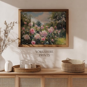 Puede incluir: Impresi&oacute;n enmarcada de un jard&iacute;n con rosas rosas. El marco de madera cuelga sobre un mueble de madera. El texto "YORKSHIRE PRINTS" es visible. Tambi&eacute;n hay un jarr&oacute;n con flores secas y una cesta.