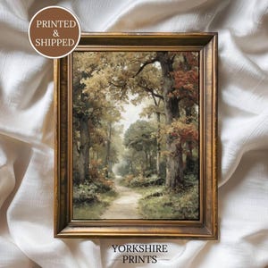 Può includere: Un dipinto paesaggistico incorniciato che raffigura un sentiero nel bosco circondato da alberi con fogliame verde e dai toni autunnali. L'opera è in una cornice color oro scuro. Il testo PRINTED & SHIPPED e YORKSHIRE PRINTS è visibile.