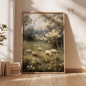 Op de afbeelding: Een ingelijst schilderij van een pastorale landschap met een kudde schapen die grazen in een weide vol wilde bloemen. Het kunstwerk heeft een zacht, gedempt kleurenpalet en een serene sfeer.