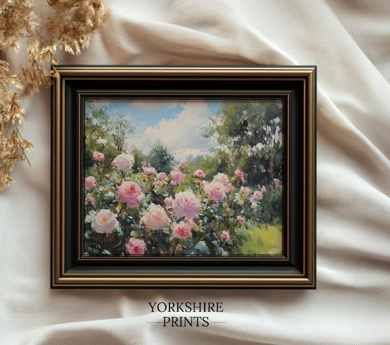 Puede incluir: Pintura enmarcada que representa un jard&iacute;n de rosas rosas bajo un cielo azul con nubes blancas. La obra de arte est&aacute; en un marco negro y dorado. El texto "YORKSHIRE PRINTS" est&aacute; en la parte inferior del marco.