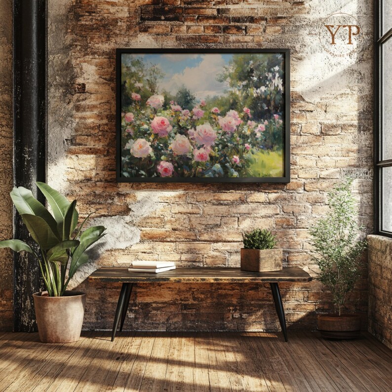 Puede incluir: Una pintura enmarcada de rosas rosas en un jard&iacute;n cuelga de una pared de ladrillo. Un banco de madera con patas negras se encuentra debajo de la pintura. Una planta en maceta grande y una peque&ntilde;a planta perenne en maceta est&aacute;n a ambos lados del banco.