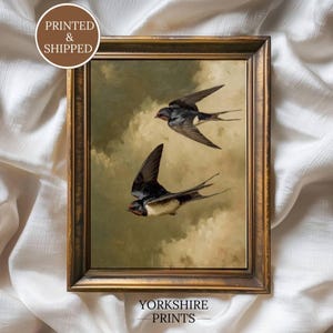 Könnte beinhalten: Ein gerahmter Kunstdruck mit zwei fliegenden Schwalben vor einem bewölkten Himmel. Das Kunstwerk befindet sich in einem dunkel bronzefarbenen Rahmen. Der Text auf dem Bild lautet PRINTED & SHIPPED und YORKSHIRE PRINTS. Die Vögel haben dunkles Gefieder.