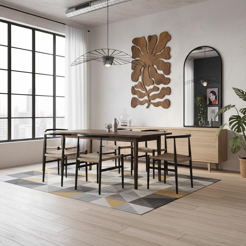 Peut inclure: Une salle &agrave; manger moderne avec une table et des chaises en bois fonc&eacute;, un tapis g&eacute;om&eacute;trique et une grande fen&ecirc;tre. Une &oelig;uvre d'art murale en bois et un miroir &agrave; cadre noir compl&egrave;tent le d&eacute;cor. Un luminaire &eacute;l&eacute;gant est suspendu au-dessus de la table.
