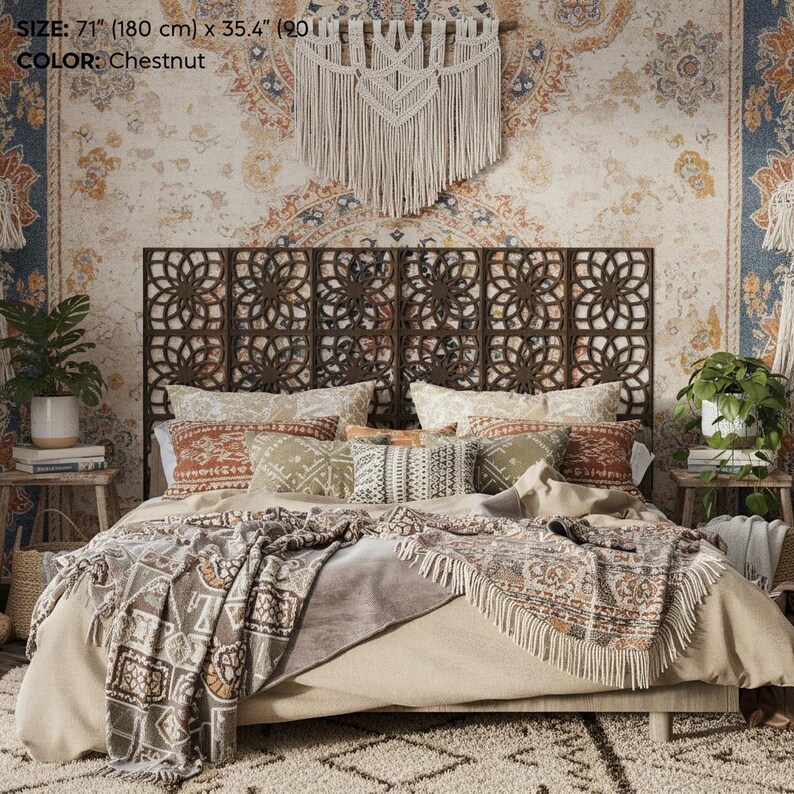 K&ouml;nnte beinhalten: Ein Schlafzimmer mit einem Bett mit dekorativem Kopfteil und gemusterter Bettw&auml;sche. Das Kopfteil ist dunkelbraun und hat ein lasergeschnittenes Design. Das Bett ist mit Kissen, einer gemusterten Decke und einer cremefarbenen Tagesdecke ausgestattet. Der Raum hat eine Boho-&Auml;sthetik.