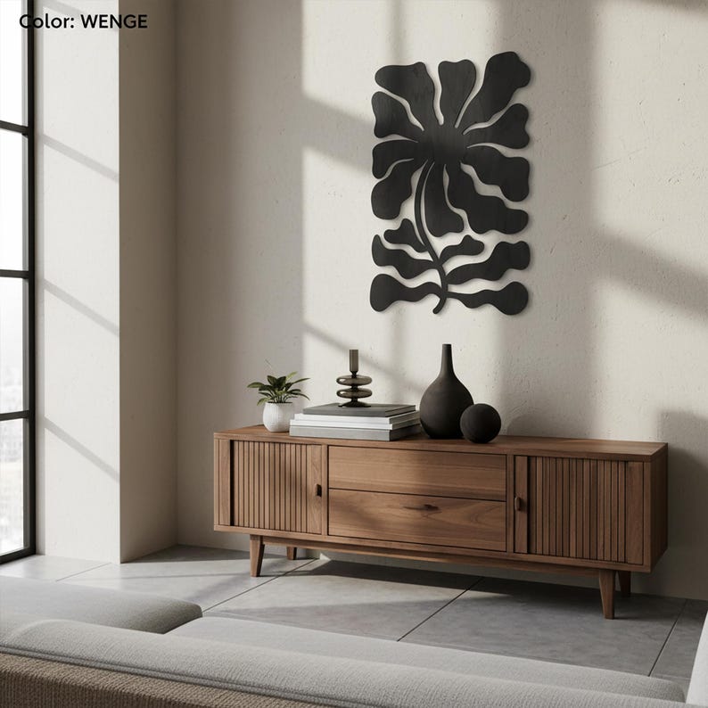 Peut inclure: Une d&eacute;coration murale florale en m&eacute;tal noir est suspendue au-dessus d'un meuble en bois. Le meuble a un design moderne du milieu du si&egrave;cle. Une petite plante en pot, des livres et des objets d&eacute;coratifs sont plac&eacute;s sur le dessus.