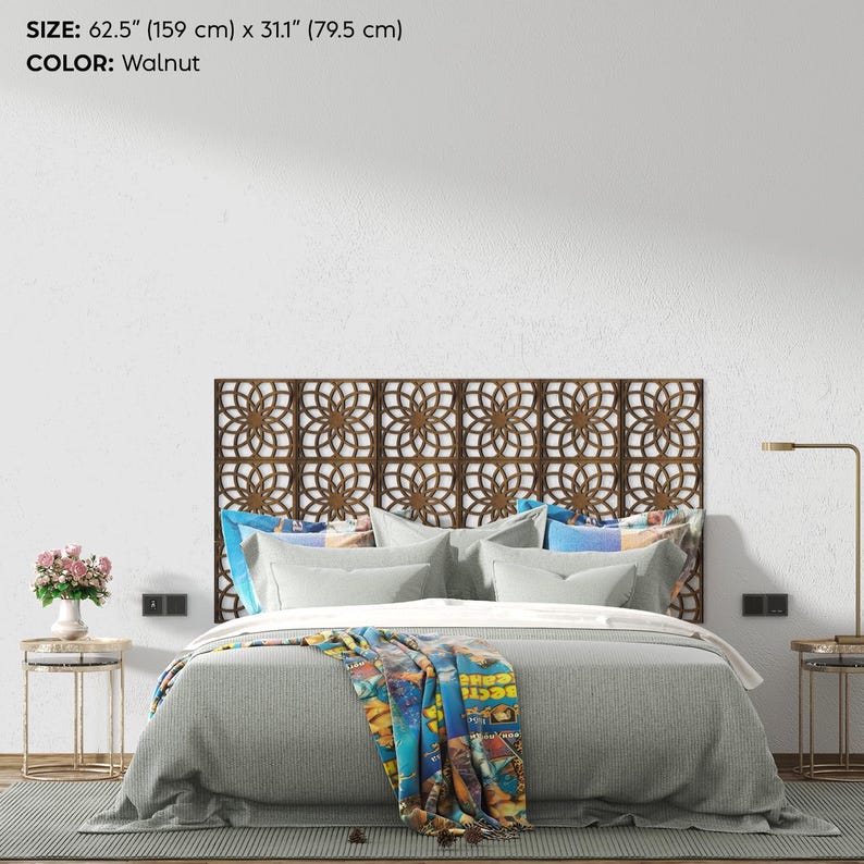 K&ouml;nnte beinhalten: Ein dekoratives Kopfteil in Walnussfarbe mit einem geometrischen Blumenmuster. Das Kopfteil ist 159 cm breit und 79,5 cm hoch. Das Bett ist mit grauer Bettw&auml;sche und bunten Kissen ausgestattet.