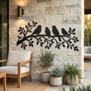 May include: A black metal wall art piece featuring a horizontal tree branch silhouette with four birds perched on it. The design includes detailed leaves extending from the branch, creating a decorative nature-inspired motif for wall mounting.