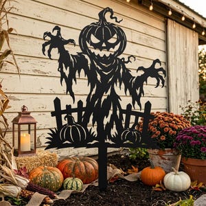 May include: A black metal garden stake featuring a cutout silhouette of a jagged-toothed pumpkin-headed scarecrow standing behind a picket fence with two small pumpkins, designed for outdoor display in a garden or lawn setting.