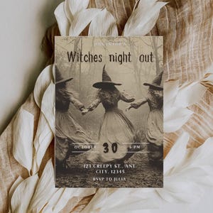 May include: A sepia-toned Halloween invitation with the text "Witches night out." The image features three witches holding hands in a forest. The date "October 30" and time "6 PM" are displayed. Includes address and RSVP information.