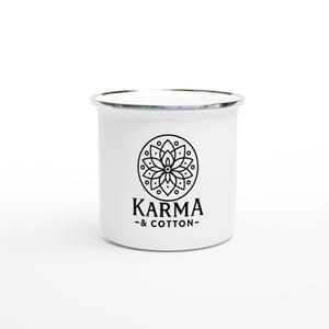 Könnte beinhalten: Weißer Emaille-Becher mit silbernem Rand. Der Becher hat ein schwarzes kreisförmiges Design mit einem Blumenmuster und dem Text "KARMA - & COTTON-" darunter. Der Becher ist für heiße oder kalte Getränke konzipiert.