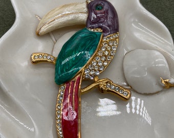 May include: A gold-tone toucan brooch with green, red, and white enamel and clear rhinestones.
