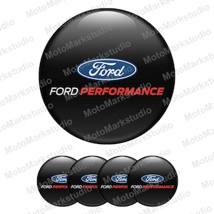 May include: A collection of black Ford Performance emblems. Each emblem displays the Ford logo in blue and white, with "FORD PERFORMANCE" in white and red. The image shows a large emblem and four smaller versions.