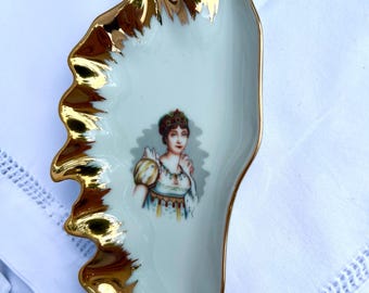 Plato antiguo de porcelana de Limoges, con retrato rococó y ribete dorado.