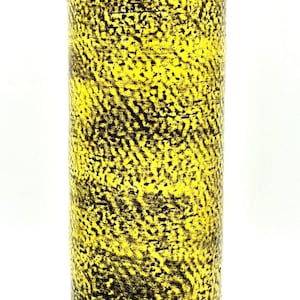 Puede incluir: Un jarrón cilíndrico con una superficie texturizada. El jarrón es principalmente amarillo con un patrón negro moteado. El diseño le da al jarrón un aspecto rústico y hecho a mano. El jarrón es adecuado para la decoración del hogar.