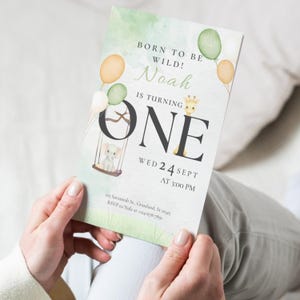 Könnte beinhalten: Eine Geburtstagseinladung mit Aquarelldesign. Die Einladung enthält den Text "Born to be Wild!" und "Noah is turning ONE". Sie enthält eine Giraffe, einen Elefanten und Ballons in Grün- und Orangetönen. Datum und Uhrzeit sind ebenfalls angegeben.