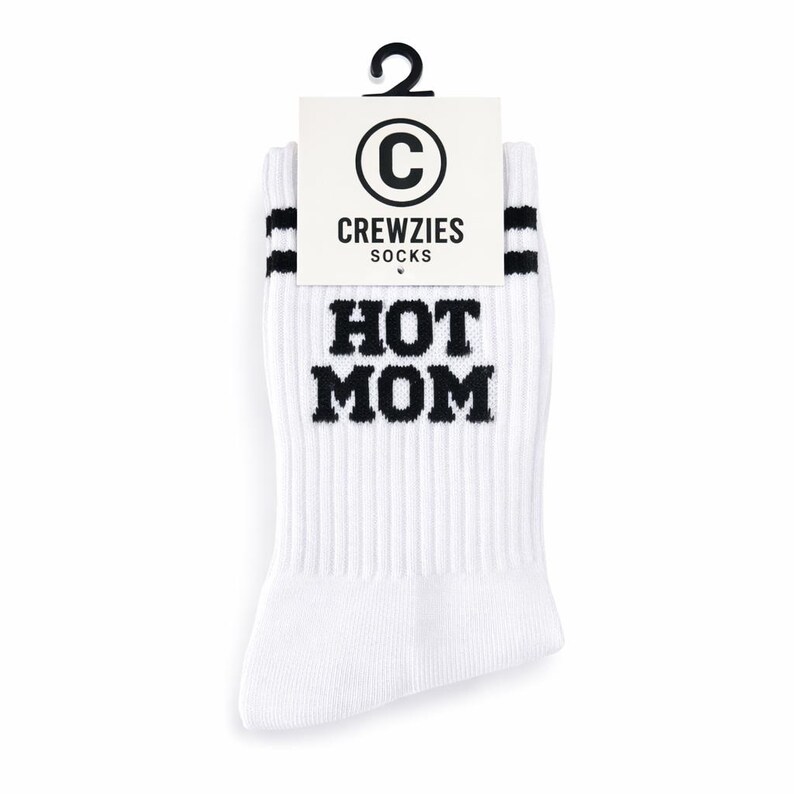 May include: White crew socks with black stripes and the text "HOT MOM" in bold, black letters. The socks have a ribbed texture and a tag that reads "CREWZIES SOCKS" with a "C" logo.