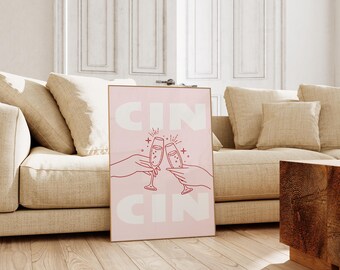 Puede incluir: Un estampado rosa enmarcado con la palabra "CIN" en letras blancas grandes en la parte superior e inferior. El estampado presenta un dibujo lineal de dos manos brindando con copas de champán. La imagen está ambientada en un salón de tonos neutros.