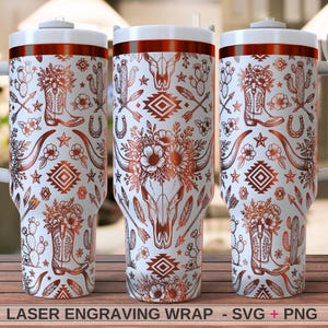 May include: Three white tumblers with handles featuring a copper-colored laser engraving wrap design of cowboy boots, cacti, flowers, arrows, stars, horseshoes, and a steer skull. The text at the bottom reads LASER ENGRAVING WRAP - SVG + PNG.