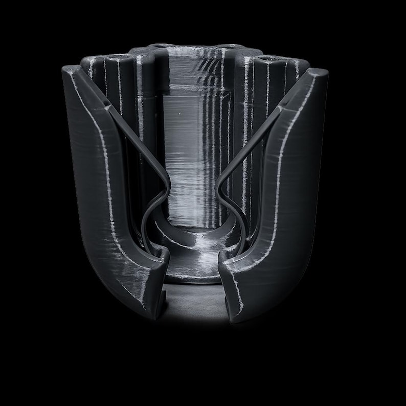 May include: A black, 3D-printed object with a complex, geometric design. The object has a central cylindrical core with vertical ridges and two curved, wing-like structures extending outwards. The overall shape is symmetrical, with a matte finish and visible layer lines.