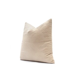 May include: Beige decorative pillow with a geometric pattern. The pillow features a textured surface with a repeating design of squares and rectangles. The pillow is made of a soft material and is designed for home decor.