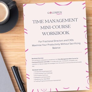 Op de afbeelding: Een werkboek getiteld "Time Management Mini-Course Workbook" met het Goldspun Support logo. De omslag is lichtroze met witte tekst. Een zwarte pen en een kopje koffie zijn zichtbaar op een houten oppervlak.