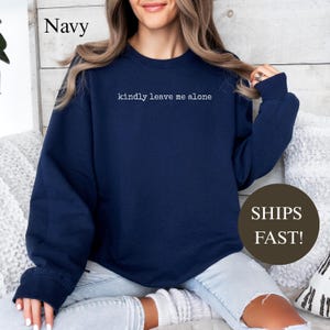 Navy sweatshirt with "kindly leave me alone" text, ships fast.