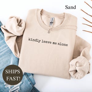 Sand sweatshirt with "kindly leave me alone" text and "SHIPS FAST!" text.