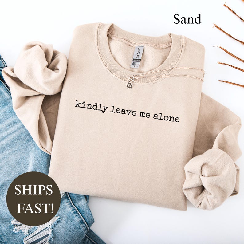 Sand sweatshirt with "kindly leave me alone" text and "SHIPS FAST!" text.