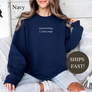 Navy sweatshirt with "apparently, I like yoga" text.
