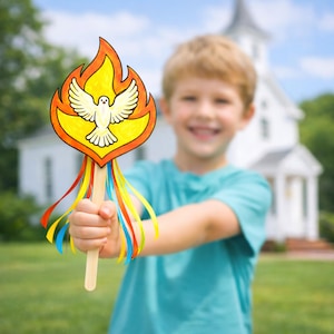 May include: A colorful craft featuring a dove within a flame design, held by a person. The dove is white with outstretched wings, set against a yellow background with orange flames. Ribbons in red, yellow, and blue dangle from the craft's wooden stick.
