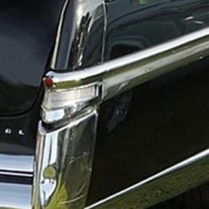 May include: Close-up of a classic car's chrome trim and a red light. The shiny chrome bumper and side trim contrast with the black body of the vehicle. The text "LOCATION ON CAR" is at the bottom.