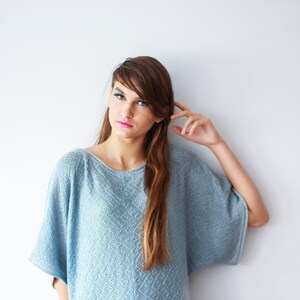 K&ouml;nnte beinhalten: Ein hellblauer Strickpullover mit lockerer Passform und einem etwas l&auml;ngeren R&uuml;ckenbund.