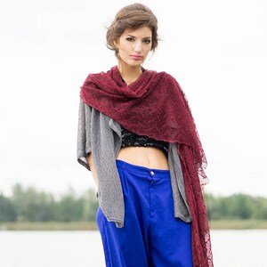 Peut inclure: Une femme portant un cardigan en tricot gris sur un haut court noir, une &eacute;charpe en dentelle bordeaux et un pantalon bleu &agrave; jambes larges.
